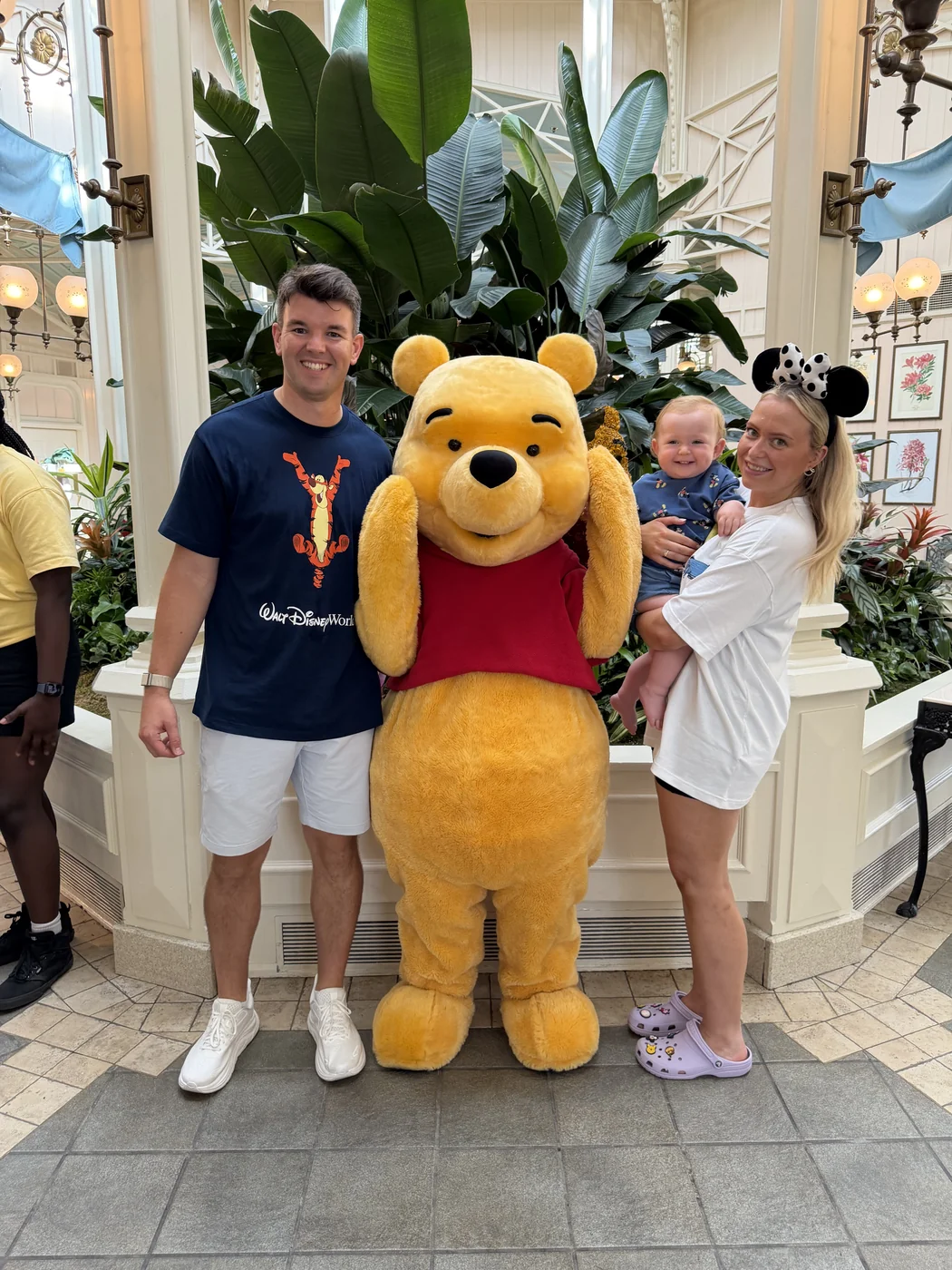 Jodie, Adam and George posing with Winnie the Pooh in the bright conservatory dining room