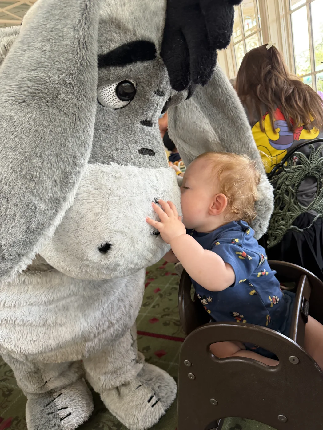 George leaning forward from his high chair to kiss Eeyore’s nose