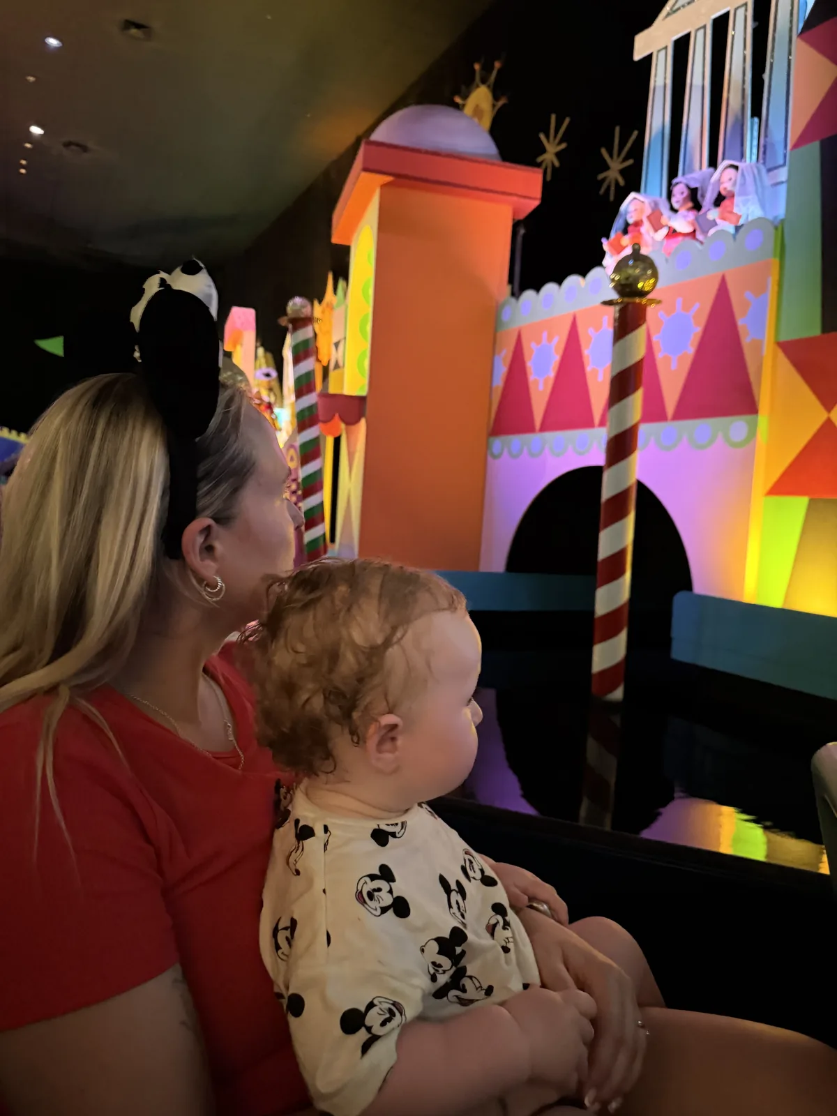 Jodie holding George on an it’s a small world boat