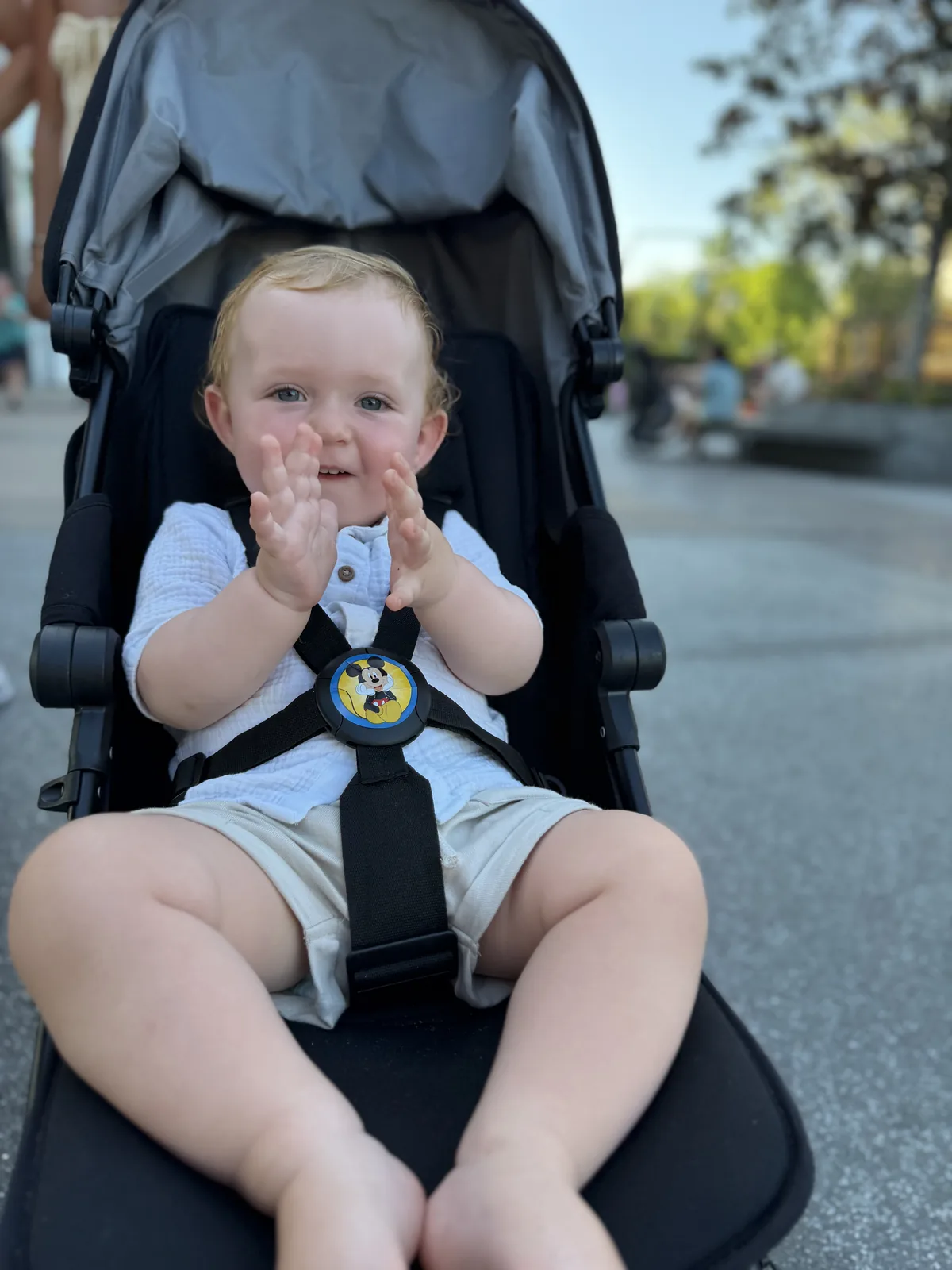 George smiling in his pushchair on a Disney day