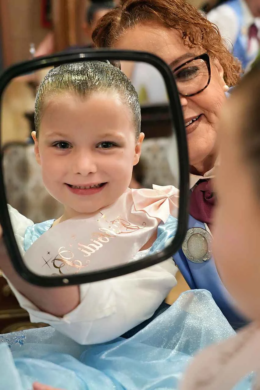 Izzy, aged five, smiling at her reflection during her Bibbidi Bobbidi Boutique makeover