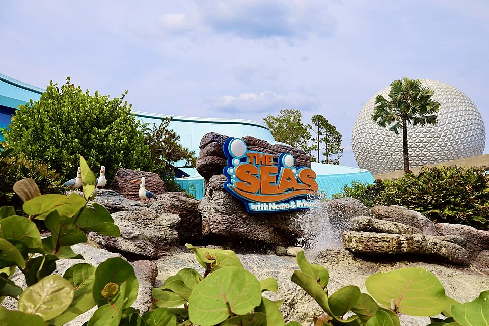 The Seas with Nemo & Friends entrance at EPCOT, with landscaped rocks and Spaceship Earth behind