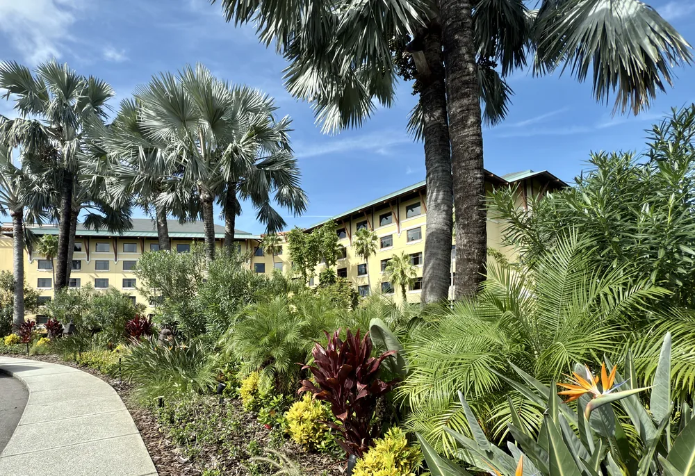 Tropical gardens, palms and hotel buildings at Loews Royal Pacific Resort.