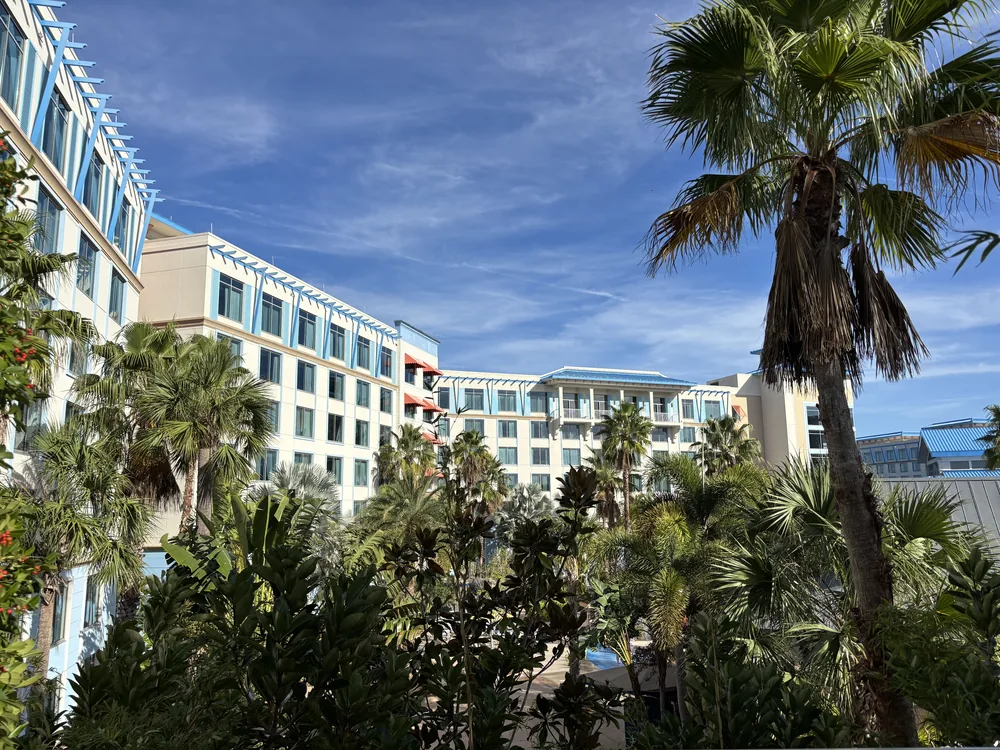 Palm trees and pastel hotel buildings at Loews Sapphire Falls Resort.