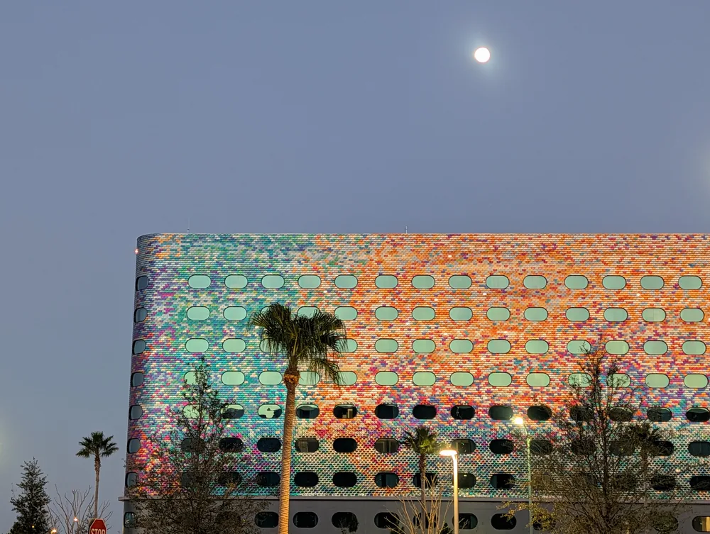 The colourful tiled exterior of Universal Stella Nova Resort beneath the moon at dusk.