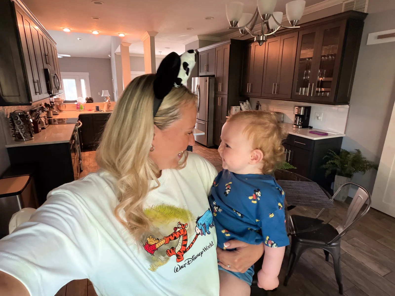 Jodie holding George in the kitchen during a family villa stay